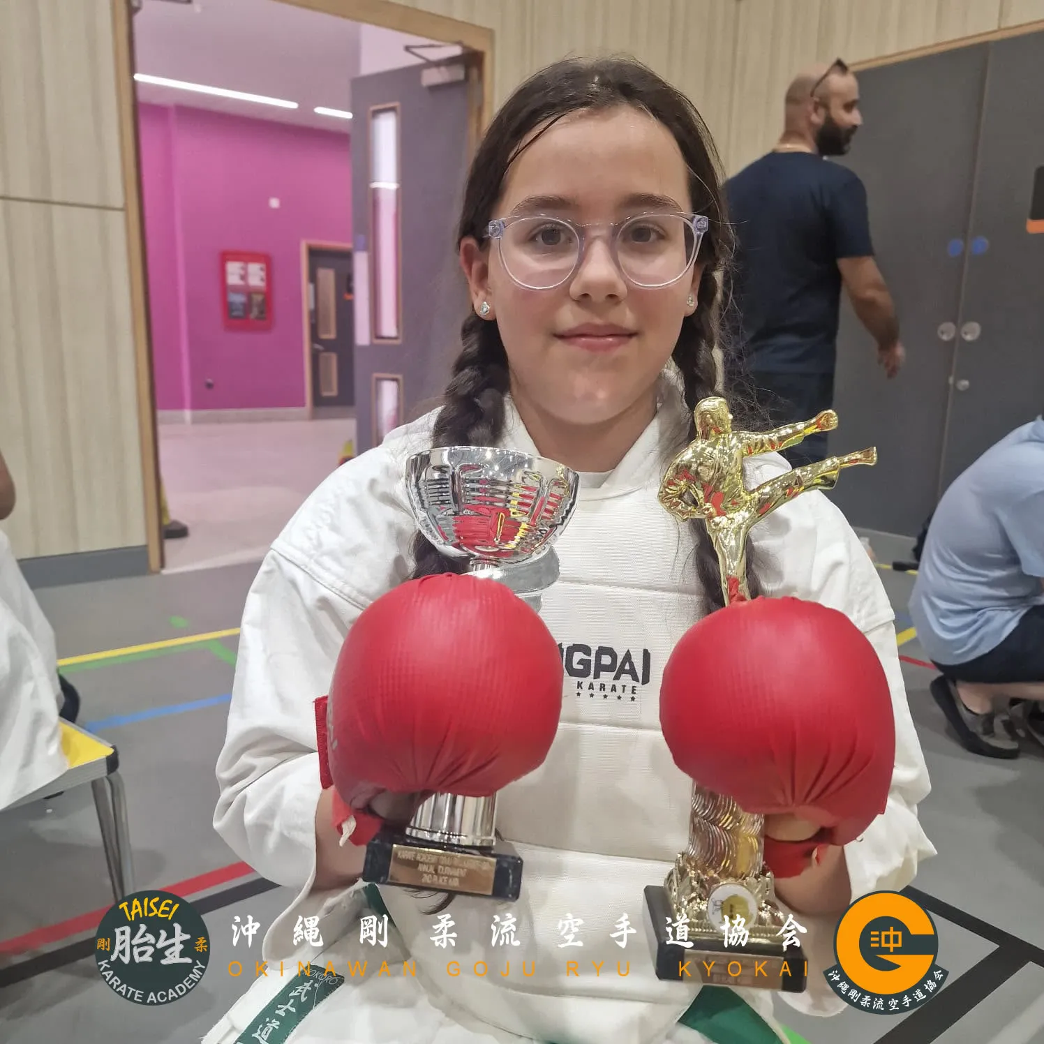 Student posing with two tournament trophies