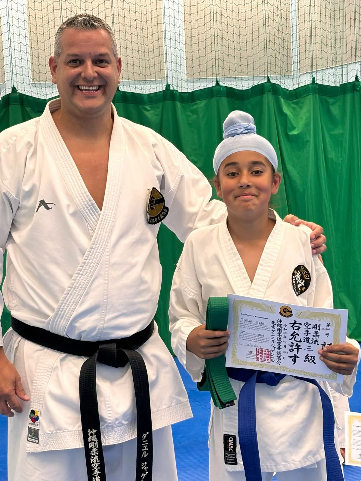 Sensei Daniel Jagemberg with a student holding her grading certificate