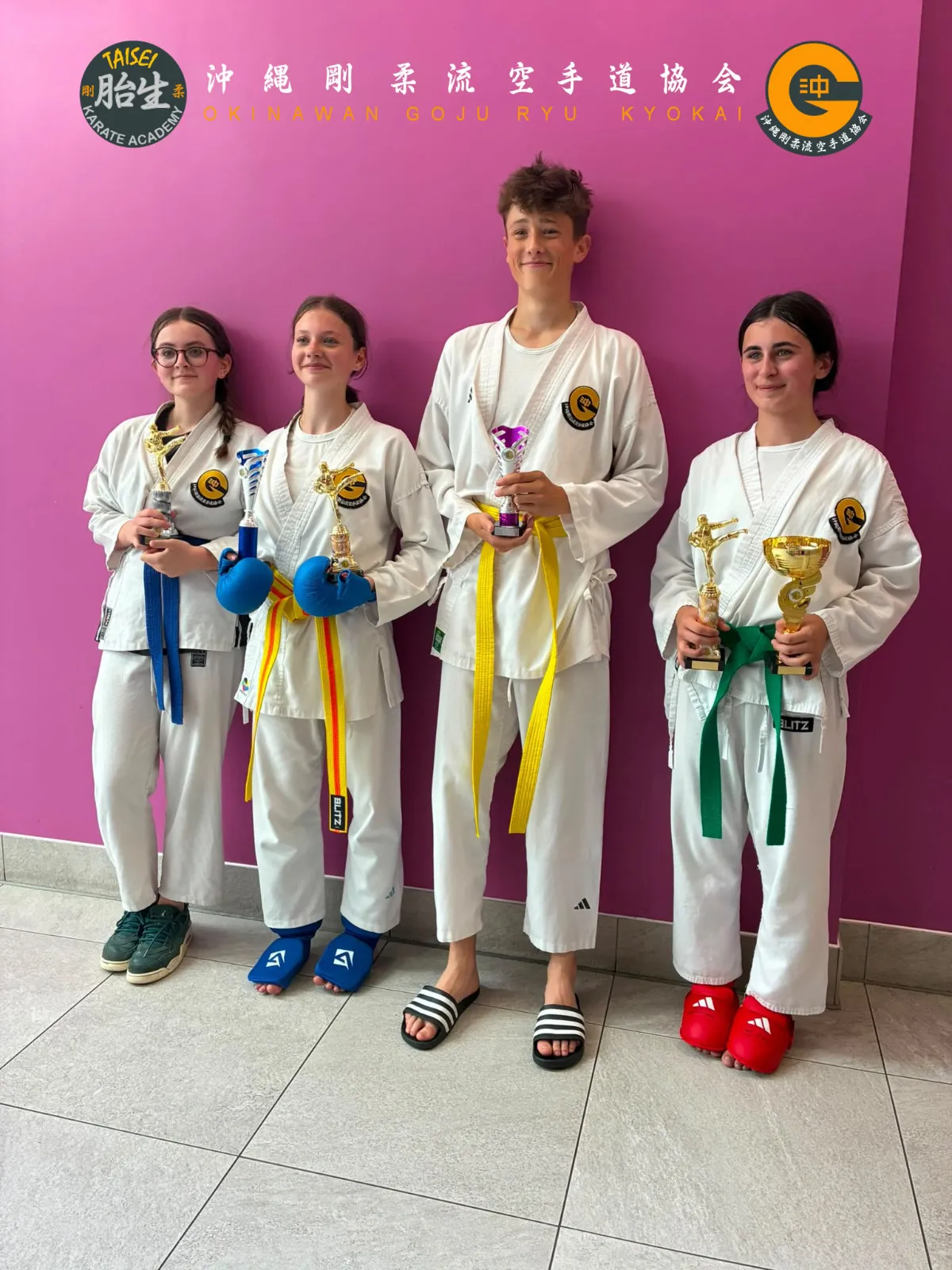 Four teen students posing together with their tournament trophies