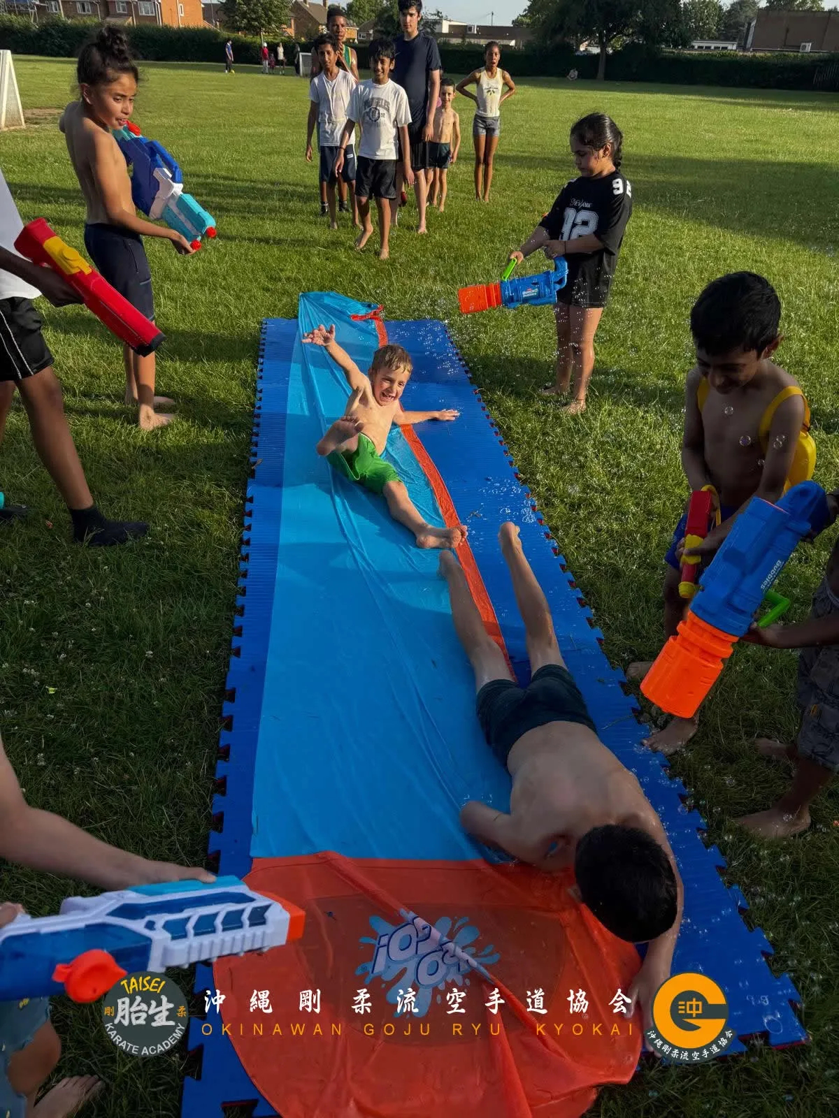 Kids playing on a water slide at a club social event
